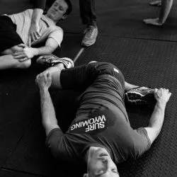 Justin Iskra, Zach Snavely Demonstrate the Brettzel Stretch in Climb Strong Class, B&W